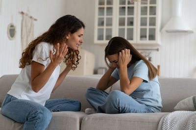 Side view of mother and daughter at home