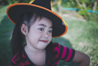 Girl wearing witch hat looking away
