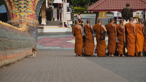 Rear view of people walking on footpath