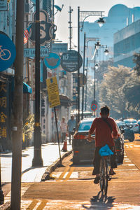 Rear view of men walking on city street