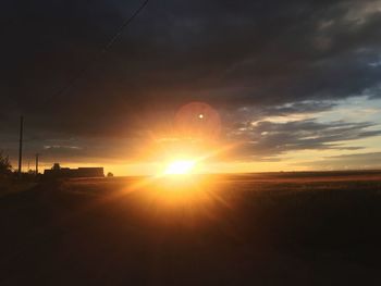 Scenic view of silhouette field against sky at sunset