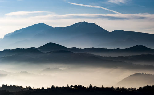 Scenic view of silhouette mountains against storm clouds