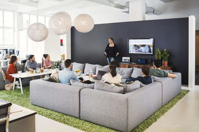 Mature businesswoman giving presentation to colleagues in modern office lobby