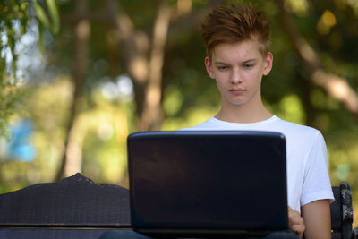 Portrait of young man using mobile phone outdoors