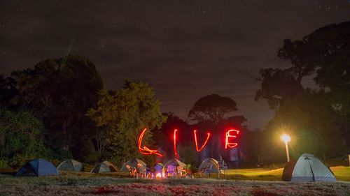 Illuminated tent against sky at night