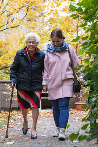 Full length of senior woman walking with daughter in park