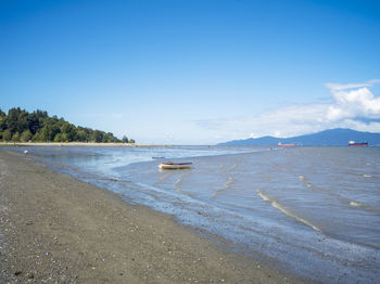 Scenic view of beach against blue sky