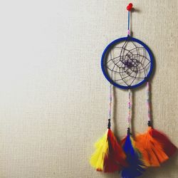 Dreamcatcher hanging from thumbtack on bulletin board