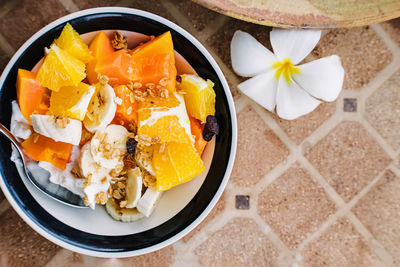 Healthy breakfast bowl with yogurt and tropic fruits on the stone table