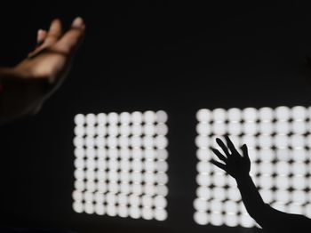 Close-up of hand playing against black background