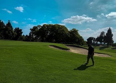 Man playing golf against sky