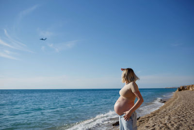 Woman on beach against sky
