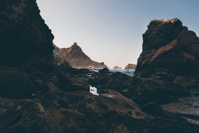 Scenic view of mountains at beach against sky