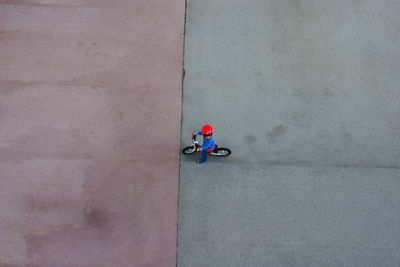 High angle view of boy with bicycle on footpath