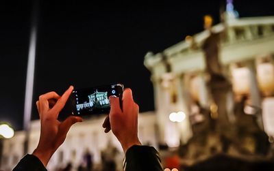 Close-up of hands holding camera at music concert