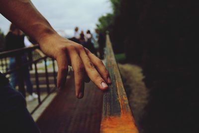 Close-up of hand touching railing