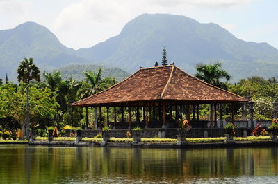 Gazebo by lake against mountains