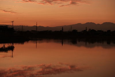 Scenic view of lake against orange sky