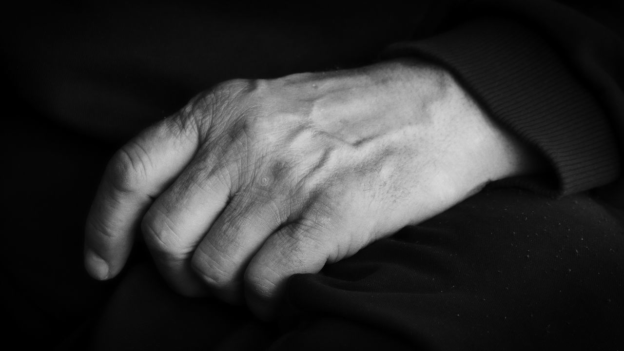 hand, black, close-up, black and white, arm, adult, monochrome photography, finger, monochrome, emotion, darkness, men, white, indoors, senior adult, one person, black background, person, sadness, holding hands, positive emotion, wrinkled