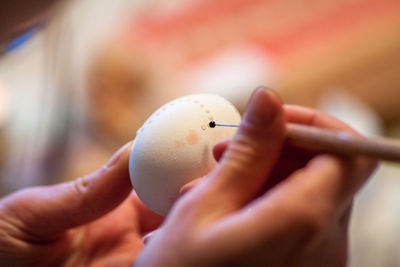 Cropped image of woman hand painting egg