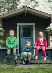 Portrait of siblings sitting on porch