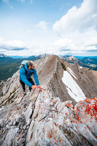 Man on rock against sky