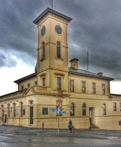 Man in front of building against cloudy sky