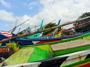 Fishing boats moored at shore against sky