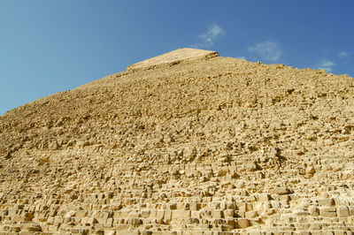 Low angle view of stone wall against sky