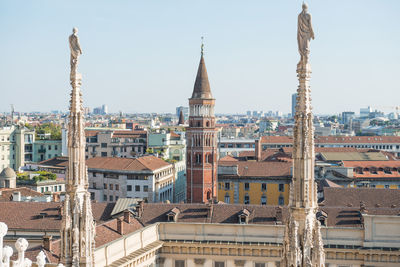 View to spires and statues on roof of duomo through ornate marble fencing. milan, italy