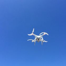 Low angle view of drone flying in sky