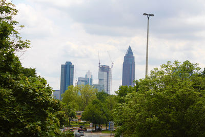 Buildings in city against cloudy sky