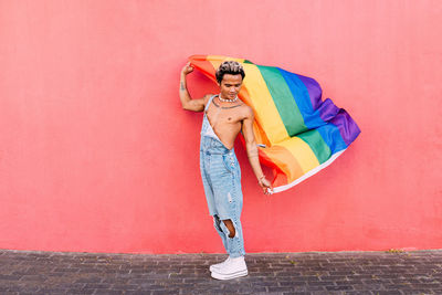 Full length of woman standing against wall