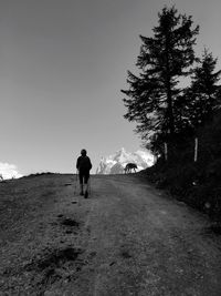 Rear view of man walking on road