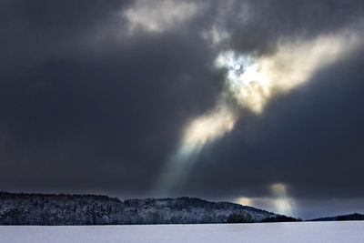 Scenic view of sea against storm clouds