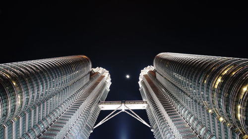 Low angle view of illuminated buildings against clear sky at night