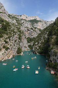 High angle view of sea with pedal boats and mountains against sky