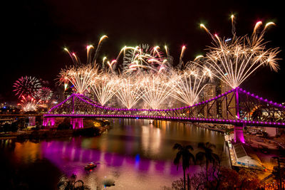 Firework display over river at night