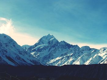 Scenic view of snowcapped mountains against blue sky