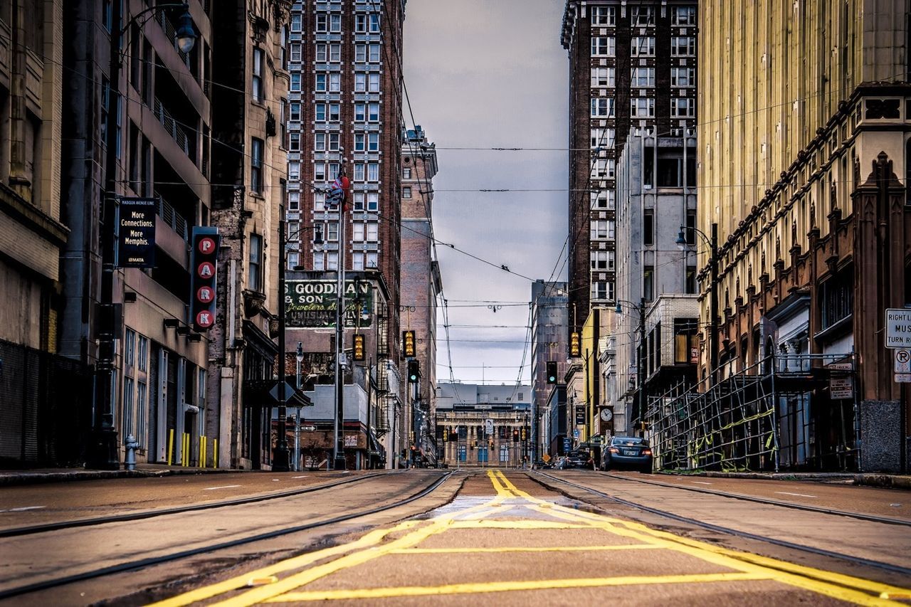 architecture, building exterior, built structure, the way forward, transportation, city, diminishing perspective, road, vanishing point, street, road marking, sky, building, empty, railroad track, city life, car, outdoors, residential building, long