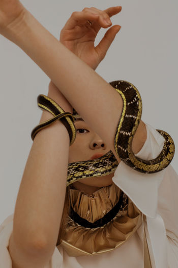 MIDSECTION OF WOMAN HOLDING PAPER AGAINST WHITE BACKGROUND