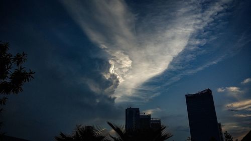 Low angle view of skyscrapers against dramatic sky