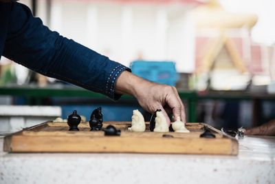 Cropped hand of man playing chess on table