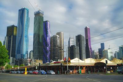 Modern buildings in city against cloudy sky