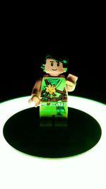 Close-up of figurine on table against black background