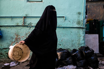 Woman with dog against wall