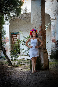 Portrait of smiling young woman standing against built structure