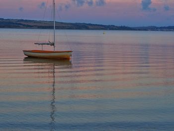 Boats in sea at sunset