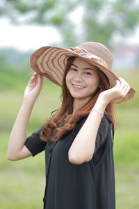 Portrait of a smiling young woman standing against blurred background