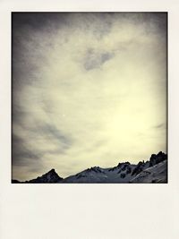 Scenic view of mountains against cloudy sky
